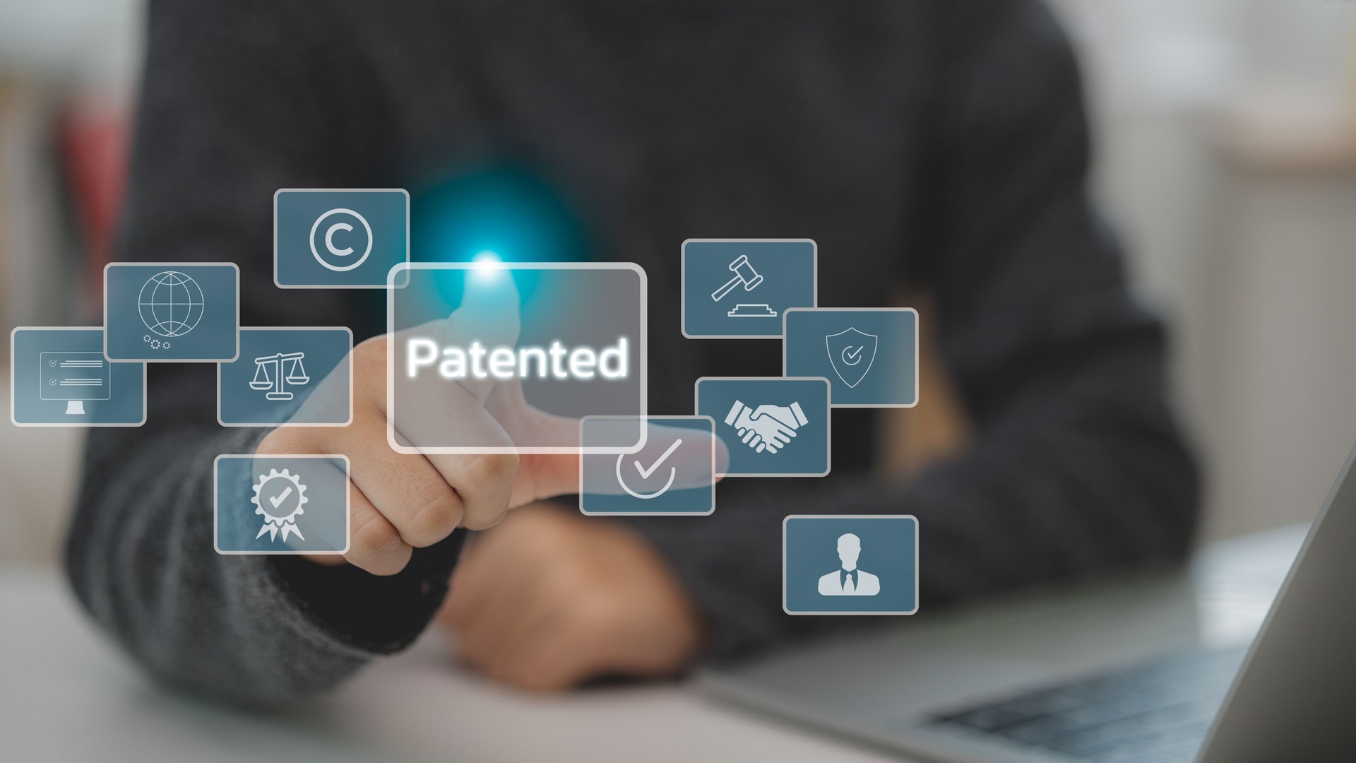 A man touches a virtual screen of a patented word with copyright icons for author rights and patented intellectual property. Patented patent copyright law business technology concept.
